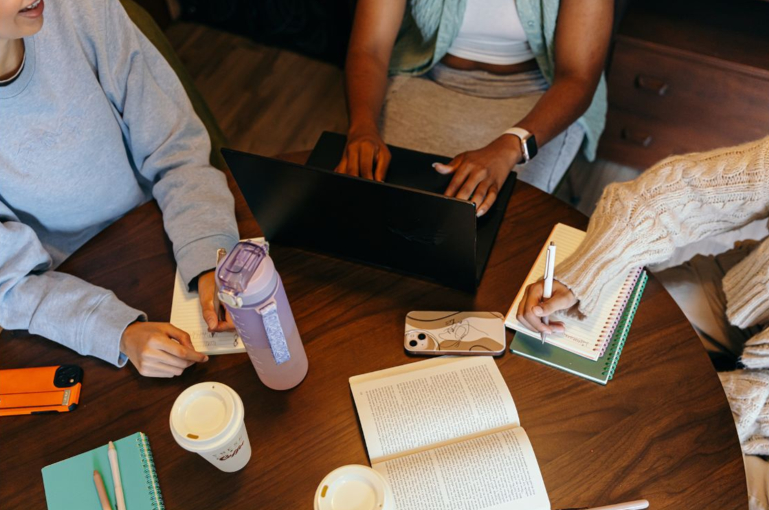 Students collaborating on college applications at a study table